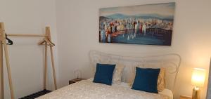 a bedroom with a bed with blue pillows and a painting at Apartment Marlena in Mokošica
