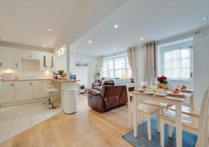cocina y sala de estar con mesa y sofá en Cutter Cottage, en Swanage