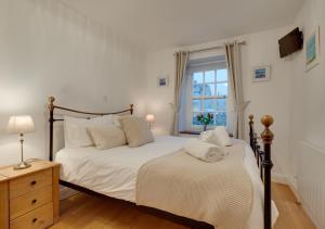 een slaapkamer met een groot bed en een raam bij Cutter Cottage in Swanage