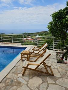 a couple of lounge chairs sitting next to a swimming pool at Apartman Slavica in Krimovice