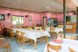 a restaurant with tables and chairs and pink walls at Tran Chau Garden Home in Cat Ba
