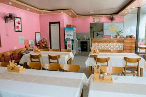 a restaurant with tables and chairs and pink walls at Tran Chau Garden Home in Cat Ba