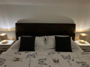 a bed with a black and white comforter and two lamps at Apartmani Đurđica in Primošten