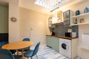 a kitchen with a table and a washing machine in a room at Joli 2 pièces proche Marais in Paris