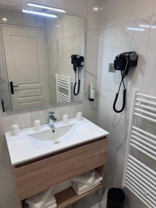 a bathroom with a sink and a mirror at Logis Le Clos Deauville Saint Gatien in Saint Gatien des Bois