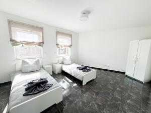 ein weißes Zimmer mit 2 Betten und 2 Fenstern in der Unterkunft Ferienwohnung Zum Alten Radlereck in Lauchhammer