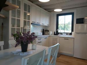 a kitchen with a table with a vase of flowers on it at Osada wspomnień in Polańczyk