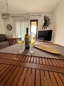 a table with two wine glasses and a bottle of wine at Casa Vacanze Chiara in Olbia