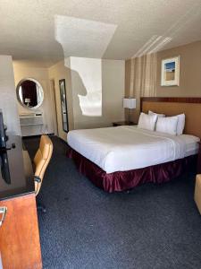 a hotel room with a large bed and a television at SureStay Hotel by Best Western Blythe in Blythe