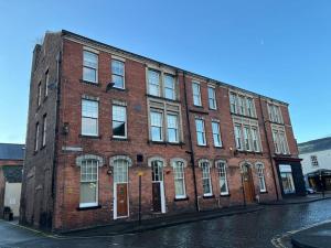 a red brick building on a street with a street at Thurnams House, Ground Floor Apt in Carlisle