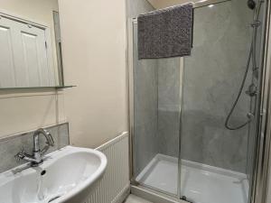 uma casa de banho com um chuveiro, um lavatório e um chuveiro em Thurnams House, Ground Floor Apt em Carlisle