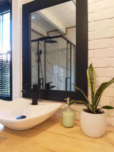 a bathroom with a large mirror and a sink at Domki nad Cichym Dworkiem in Polańczyk