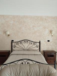 サン・ジョヴァンニ・ロトンドにあるTenuta Santa Luciaのベッドルーム1室(ベッド1台、ナイトスタンド2台、テーブル2台付)
