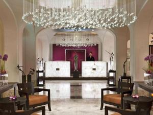 a large room with a chandelier and a man in the background at Sofitel Legend The Grand Amsterdam in Amsterdam