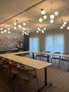 a conference room with tables and chairs and lights at ibis Styles Pontivy centre Bretagne in Pontivy