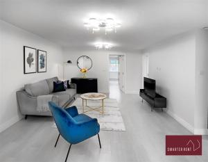 un salon avec un canapé et une chaise bleue dans l'établissement Bracknell -58c Harmanswater Road - 2 bedroom apartment, à Bracknell