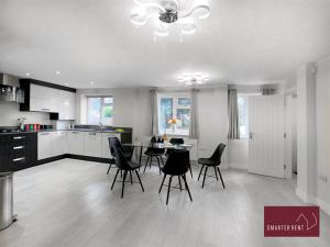 una cocina con sillas negras y una mesa. en Bracknell -58c Harmanswater Road - 2 bedroom apartment, en Bracknell
