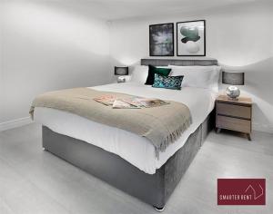 a bedroom with a large bed and a side table at Bracknell -58c Harmanswater Road - 2 bedroom apartment in Bracknell