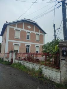 een huis met een rood hek ervoor bij Chambre privée in Tarbes