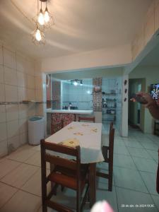 cocina con mesa y sillas en una habitación en Aconchego famíliar, en Mongaguá