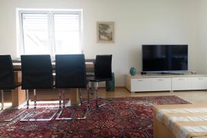 uma sala de estar com uma mesa com cadeiras e uma televisão de ecrã plano em Apartment mit Garten em Dobl-Zwaring