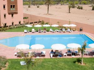 an overhead view of a swimming pool with chairs and umbrellas at Ibis Marrakech Palmeraie in Marrakesh