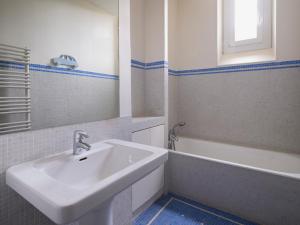 La salle de bains est pourvue d'un lavabo, d'une baignoire et d'un miroir. dans l'établissement Paris Mozart Prestige Residence, à Paris