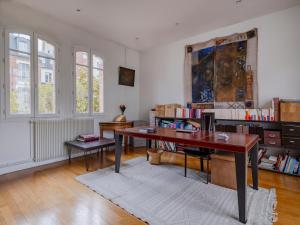 Paris Mozart Prestige Residence في باريس: مكتب مع مكتب في غرفة مع نوافذ