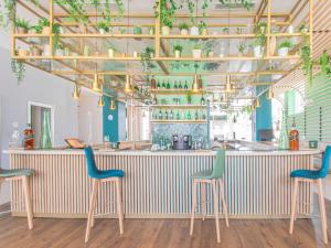 um bar com três cadeiras e um balcão com plantas em Ibis Casablanca City Center em Casablanca