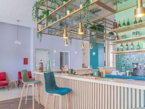 um restaurante com um bar com cadeiras azuis e verdes em Ibis Casablanca City Center em Casablanca