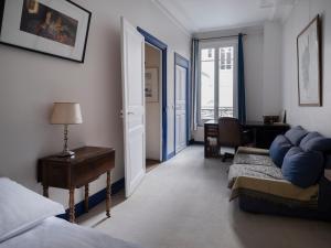 Paris Mozart Prestige Residence في باريس: غرفة نوم بسرير وطاولة ومكتب