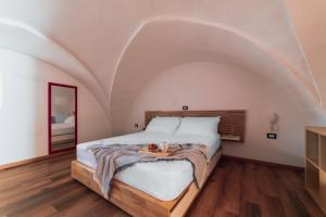 a bedroom with a large bed with an arched ceiling at Urban Charm by Diddoi in Taviano