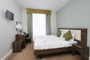 A bed or beds in a room at Hyde Park Boutique Hotel