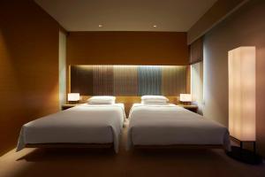 two beds in a hotel room with two lamps at Hyatt Regency Kyoto in Kyoto