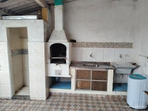 cocina con fogones y fregadero en Aconchego famíliar en Mongaguá