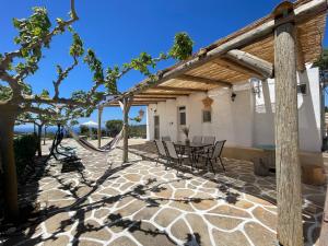 um pátio exterior com uma mesa e cadeiras em Cantera house, Kalokairines KIT em Kýthira