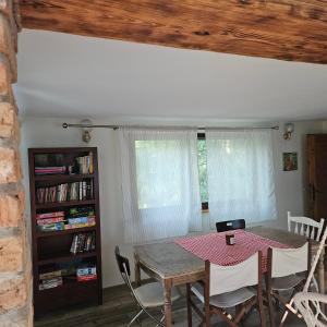une salle à manger avec une table et une étagère à livres dans l'établissement Domek Basia, à Deskurów