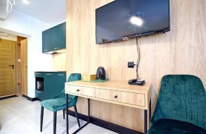 Pokój z biurkiem, 2 krzesłami i telewizorem w obiekcie Tlenoterapia w mieście Białystok