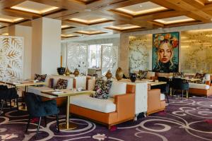 a restaurant with tables and chairs and a painting on the wall at Conrad Algarve in Quinta do Lago
