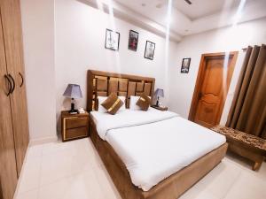 1 dormitorio con 1 cama con cabecero de madera en Family Apartments Islamabad, en Islamabad