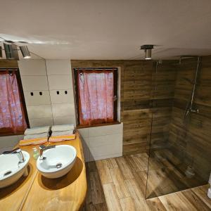 a bathroom with two sinks and a shower at Domek Basia in Deskurów