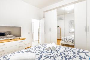 a white bedroom with a bed and a bathroom at 'Villa Vènere Deluxe' 50mt Sea-Free Parking-Garden in Terracina +19 photos