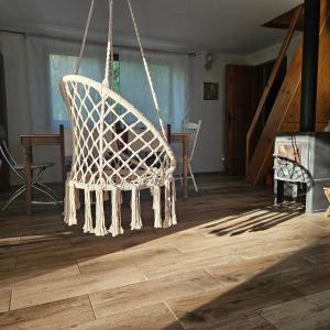 a hanging chair in a room with a wooden floor at Domek Basia in Deskurów