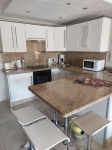 une cuisine avec des armoires blanches et un comptoir en marbre dans l'établissement NICE 1 BEDROOM APARTMENT LOS CRISTIANOS, à Los Cristianos