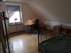 1 dormitorio con cama, escritorio y ventana en Drei Zimmer Appartment mit Küche & Bad, en Weingarten