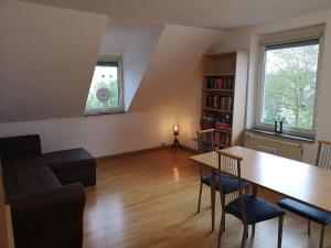 sala de estar con mesa y sofá en Drei Zimmer Appartment mit Küche & Bad, en Weingarten