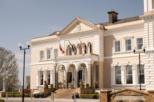 um grande edifício branco com uma bandeira americana em Manor House Country Hotel em Enniskillen