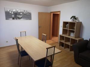 sala de estar con mesa de madera y sillas en Drei Zimmer Appartment mit Küche & Bad, en Weingarten