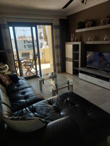 een woonkamer met een leren bank en een glazen tafel bij NICE 1 BEDROOM APARTMENT LOS CRISTIANOS in Los Cristianos