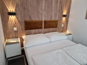 een slaapkamer met 2 bedden en 2 nachtkastjes bij Sweet Retreat Apartment Lahr in Lahr